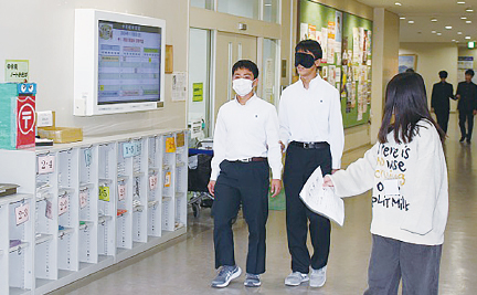 写真：アイマスクを着用し、校内を歩く体験の様子