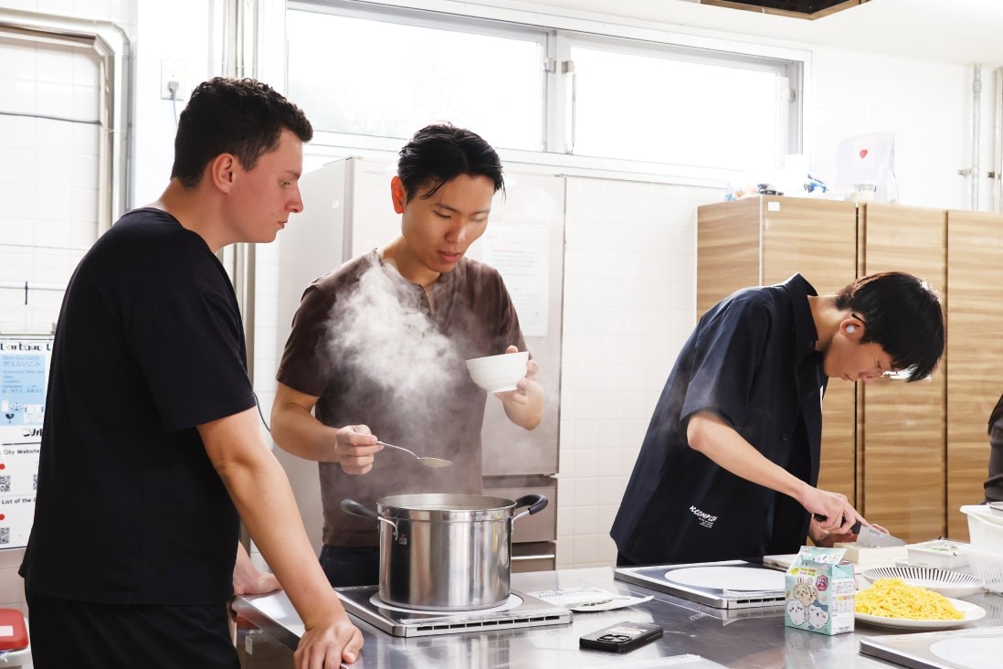 キッチンに並んで調理する学生と留学生