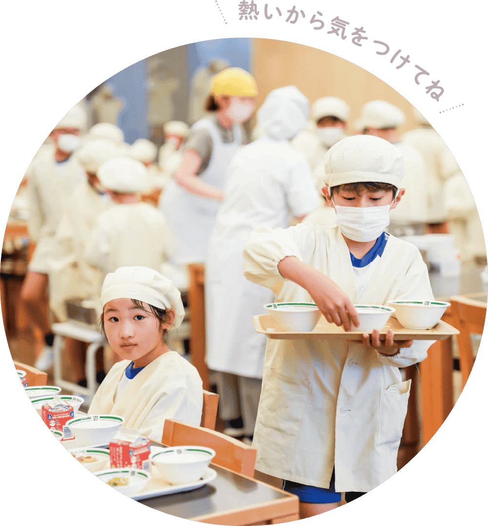 給食当番として配膳する児童
