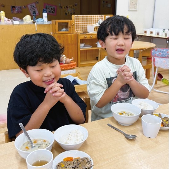 手を合わせて食前のお祈りをする園児